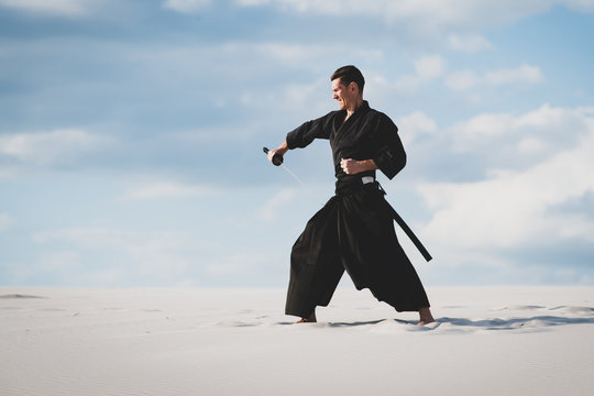 Man training martial arts in desert