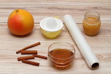 Cellulite treatment from honey, cinnamon and grapefruit juice.  Ingredients for homemade anti cellulite wrap on the table