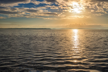 Obraz premium Sun rays beaming through picturesque clouds above the sea. Sun, clouds and water, sea photography.