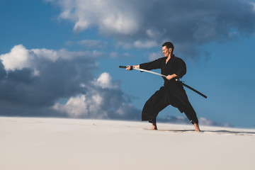 Man training martial arts in desert