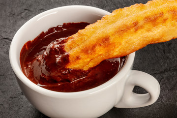 A closeup of traditional Spanish porras with hot chocolate, a typical Madrid Sunday breakfast