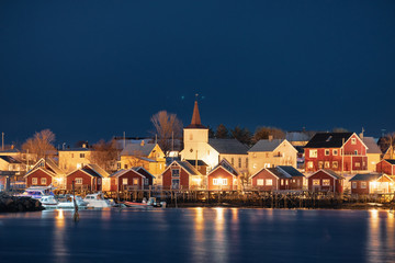 Fototapeta na wymiar White church in fishing village on coastline at night