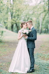 Fototapeta na wymiar Beautiful young couple in the atmospheric forest. Wedding in the European style fine art.