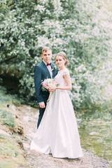 Fototapeta na wymiar Beautiful young couple in the atmospheric forest. Wedding in the European style fine art.