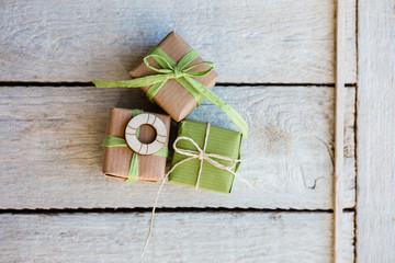 Geburtstag - Kleine Geschenke in hellgrün und Kraftpapier auf hellen Holz mit Rettungsring aus Holz