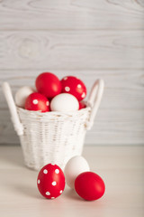 Happy Easter! Painted Easter eggs - red, white and red with white polka dots on a gray wooden background.