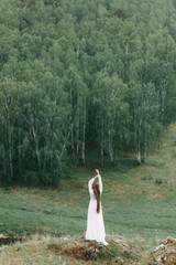 Morning bride on a beautiful panoramic location. Girl in boudoir dress and cliffs.