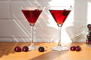 Cocktails with cherry and ice on white background