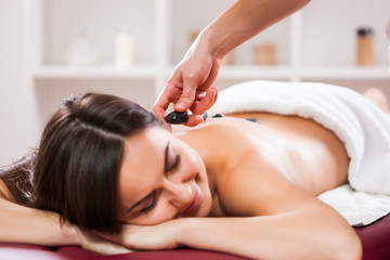 Obraz na płótnie Canvas Young woman is enjoying massage on spa treatment. 