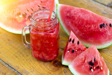 Fresh watermelon smoothie in the mason jar on wooden background. Summer,  healthy organic food concept.