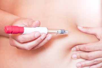 Woman is injecting hormones by single use syringe pen with dose. Ectrocorporal conception, Diabetes...