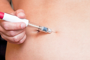 Woman is injecting hormones by single use syringe pen with dose. Ectrocorporal conception, Diabetes concept.