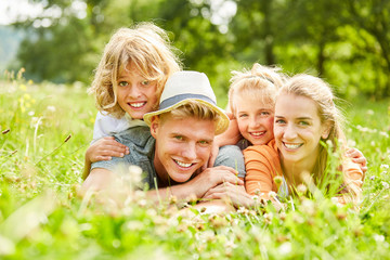 Eltern und Kinder liegen glücklich im Gras