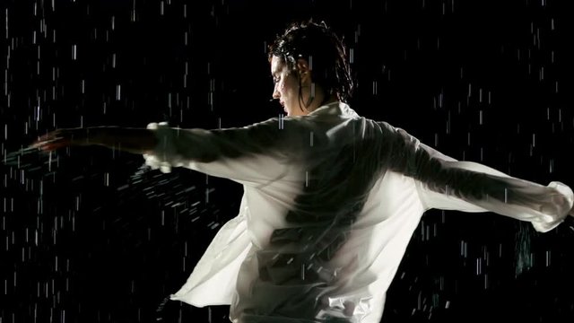 Beautiful woman dancing in the rain. Slow Motion.