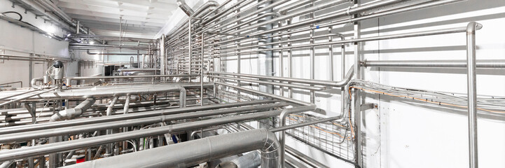 Industrial zone background concept. Steel pipelines and cables in manufacture interior