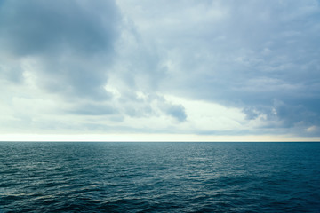 Obraz premium Cloudy evening sky over the sea surface of the water