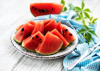 Watermelon with green leaves on a old wooden table