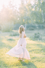 Aerial photo shoot at sunset in the forest. Girl in a flying dress in the style of fine art.
