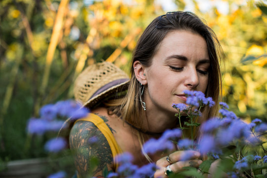 Woman Smelling Vervain Flowers In Her Garden