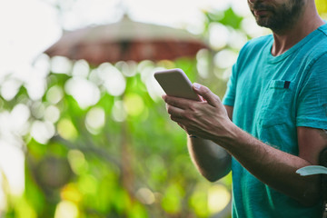 Modern man using cellphone outdoors.