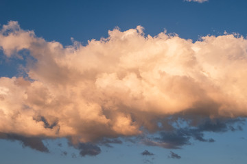 White clouds in summer blue sky at golden hour