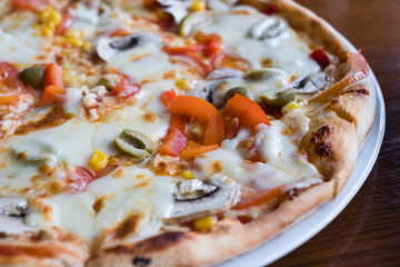 Close up Italian pizza with olives, tomatoes and che