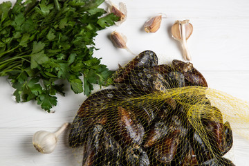 Fresh raw mussels in a grid with parsley and garlic