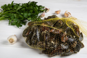 Fresh raw mussels in a grid with parsley and garlic