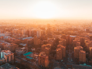 Scenic futuristic city skyline of modern downtown in beautiful orange sunset sunrise golden hour time. Urban cityscape view of streets in megapolis. Real estate concept