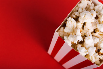 Bucket of popcorn on red background