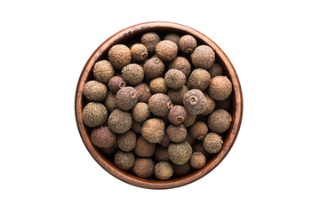 allspice spice in wooden bowl, isolated on white background. Seasoning top view