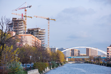 Fototapeta na wymiar New residential and office block buildings being constructed next to river in city center of Bucharest.