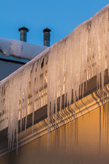icicles on the roof in the evening sunlight