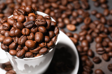 Coffee beans in coffee cup on black background