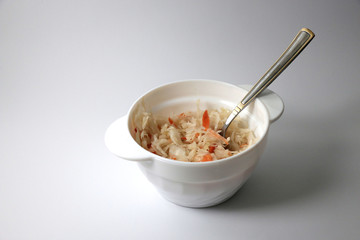 тарелка квашеной капусты на белом фоне