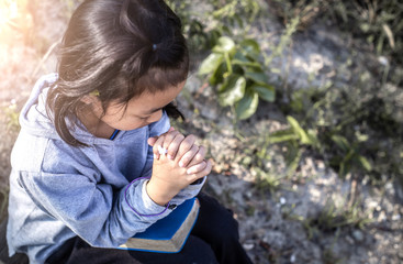 Little girl christian with praying on bible. Peace, hope, praying concept.
