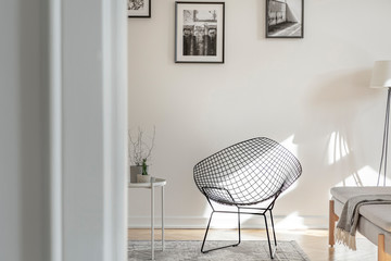 Industrial chair on the middle of black and white interior with photos on the wall