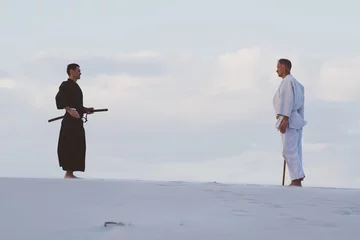 Photo sur Plexiglas Arts martiaux Two men practicing Japanese martial arts in desert