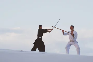 Deux hommes pratiquant les arts martiaux japonais dans le désert