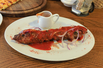 Kebab. Traditional Middle-Eastern Food. It is a long cutlet roasted on the grill and a gravy with spicy tomato sauce.