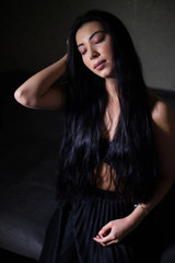 Fototapeta premium lowkey portrait of beautiful woman with closed eyes over dark background
