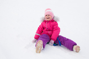 Fototapeta na wymiar little girl riding on snow slides in winter time