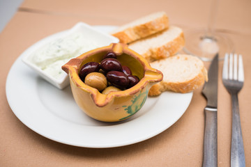 Fresh olives with butter and slices of baguette