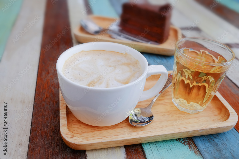 Wall mural Coffee in a white cup and chocolate cake on a wooden table