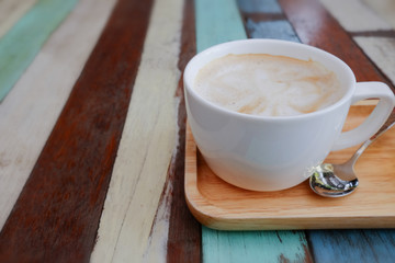 Coffee in a white cup and chocolate cake on a wooden table