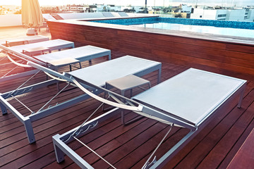 Sunbeds near swimming pool in the modern building