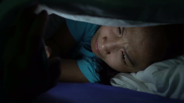 Asian woman play smartphone in the bed at night,Thailand people,Addict social media,Play internet all night,Lychnobite	