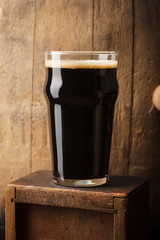 Pint of stout near a barrel