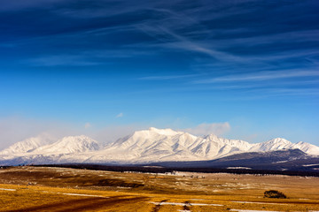 Winter landscape of Mongolia. White mountain background and yellow valley