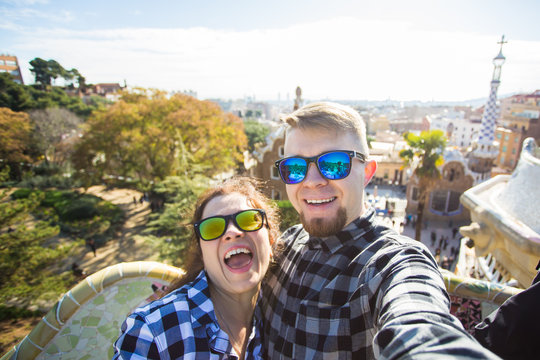 Travel couple happy making selfie portrait with smartphone in Park Guell, Barcelona, Spain.